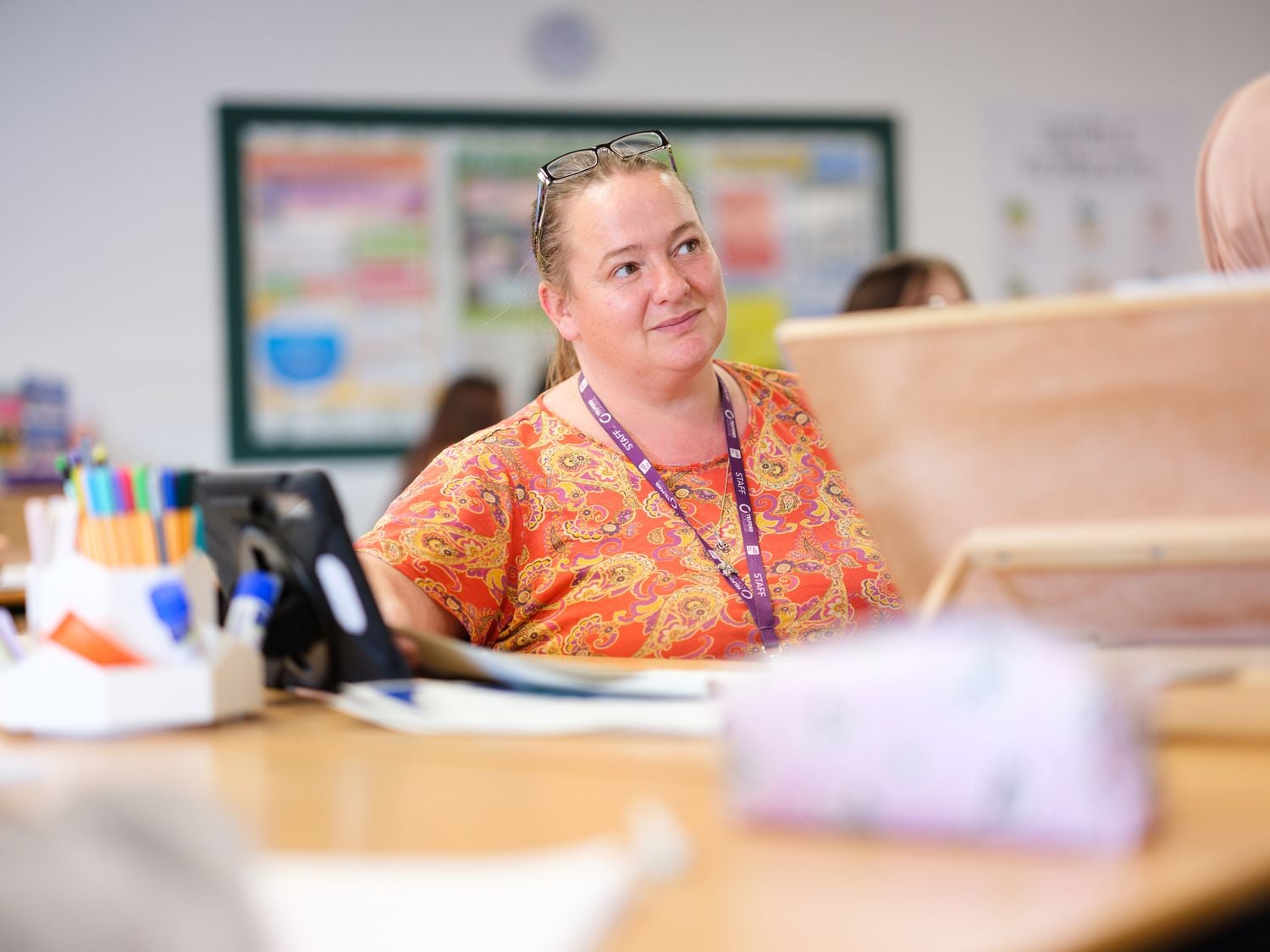 education tutor at desk in classroom