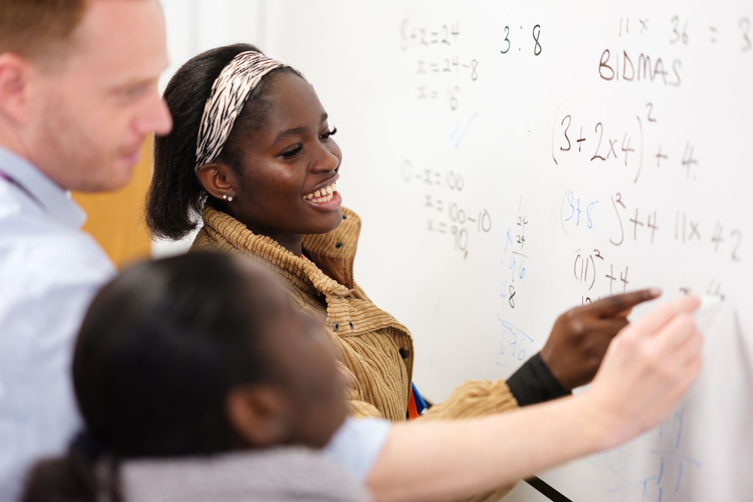 Maths & English students writing on board