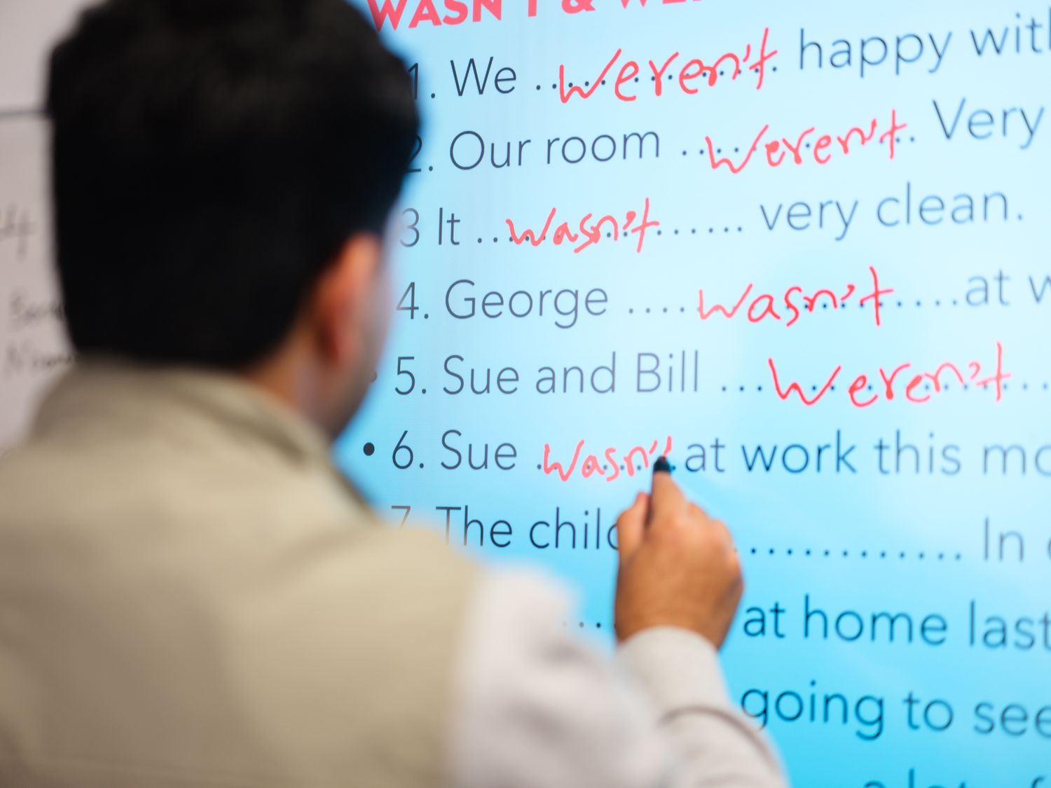 Maths & English student writing on board