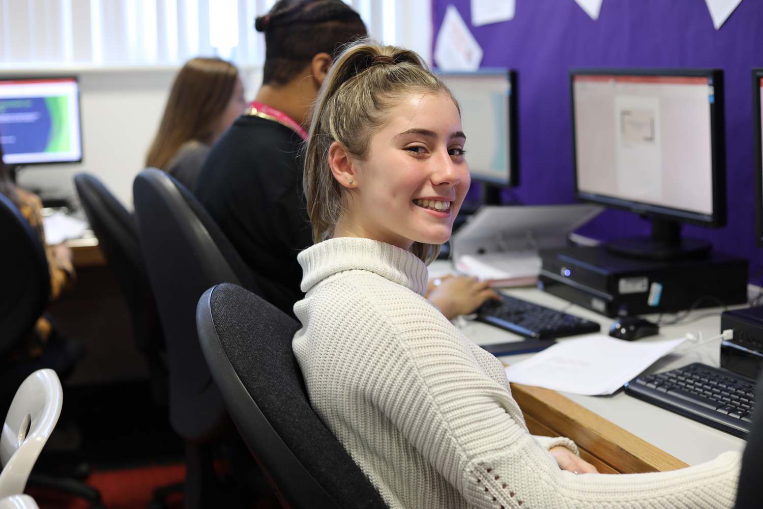 business student sat at desk in classroom