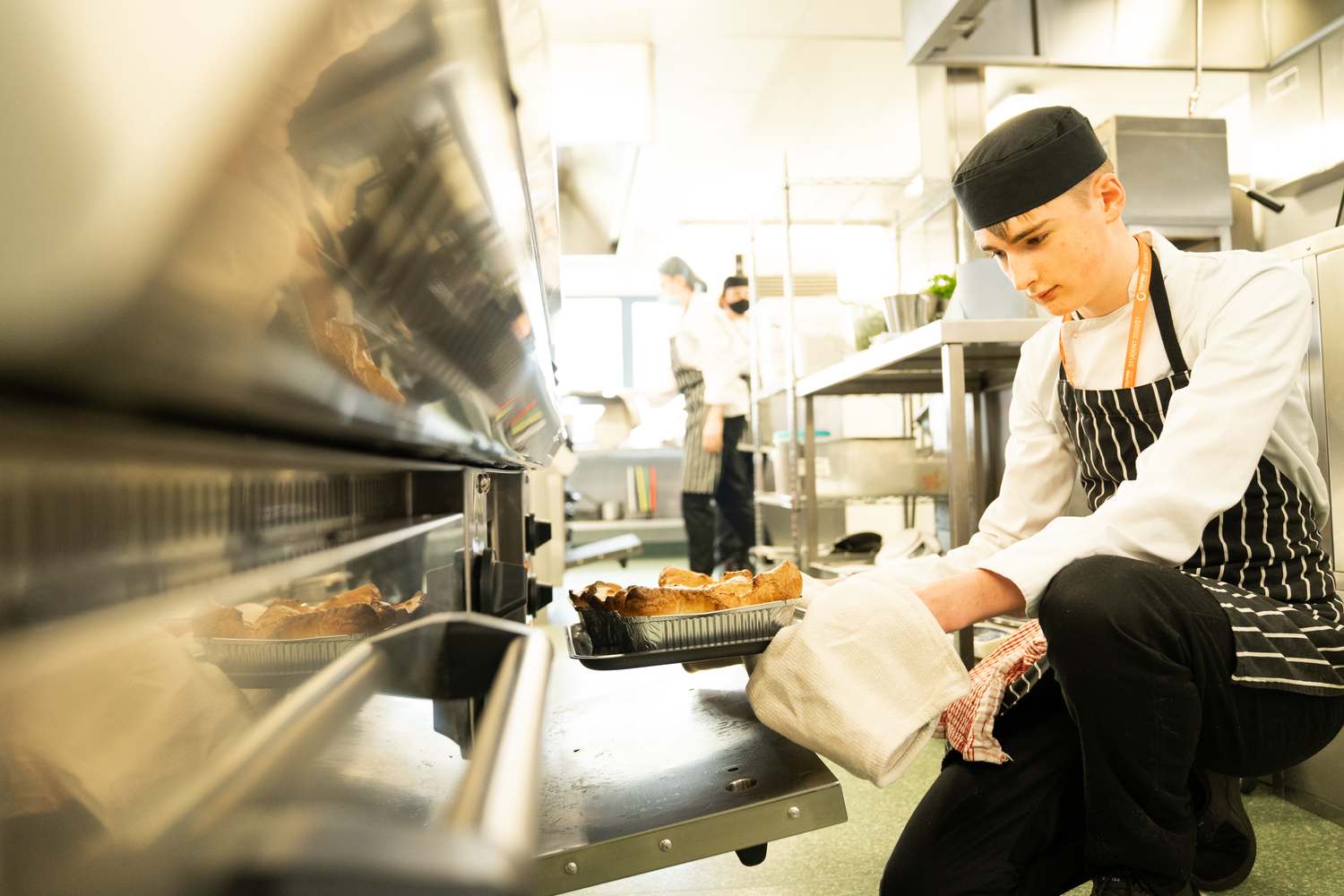 catering students in kitchen preparing food