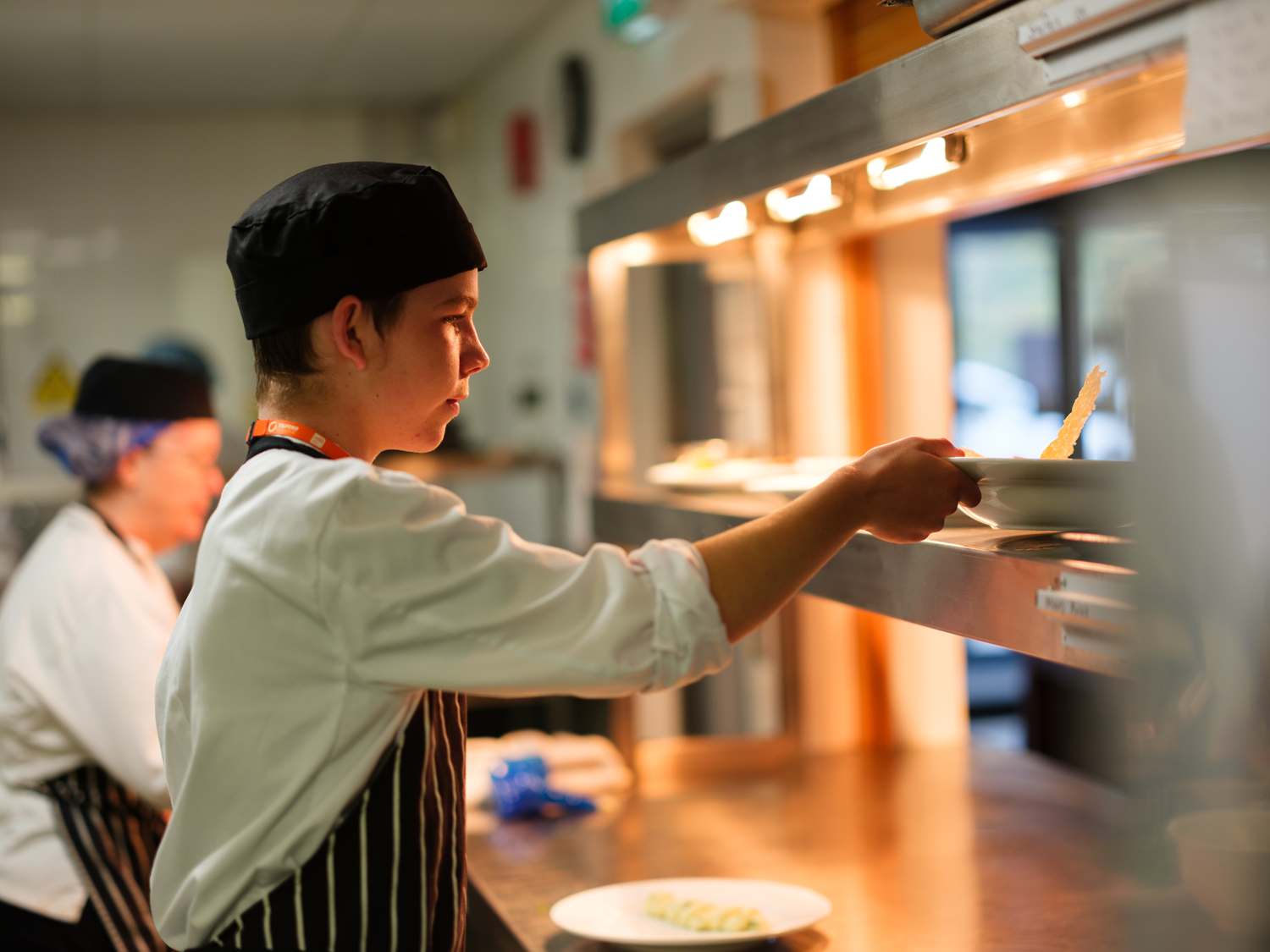 catering students in kitchen preparing food