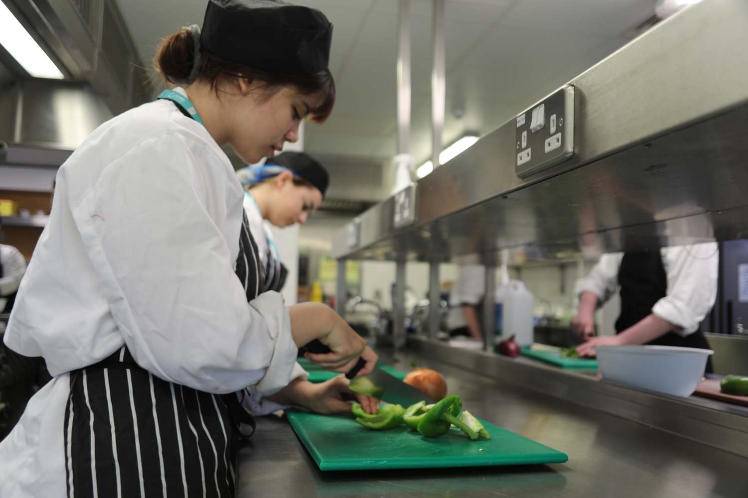 catering students in kitchen preparing food
